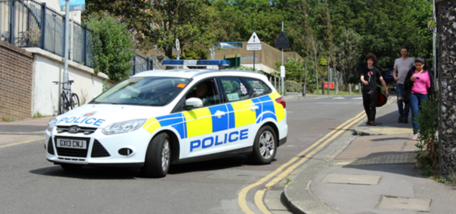 Police car parked in the road due to a car accident nearby.